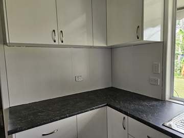 Kitchen with new oven, cooktop and cabinetry installed