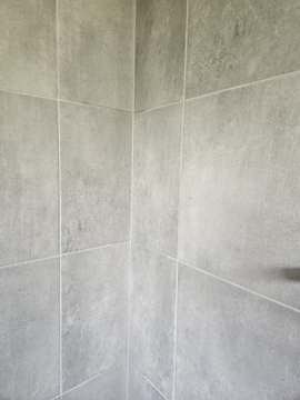 Completed grey tiled bathroom walls